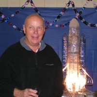 Astronaut Story Musgrave poses in front of the space shuttle ice sculpture graciously donated by Dol