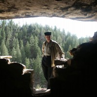 Ed Los peers into one of the ruins at Walnut Canyon